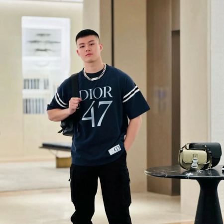 A youthful man dressed in Dior 47 Logo Print T-Shirt