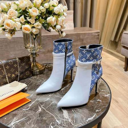 a pair of Louis Vuitton High-Heeled Ankle Boots In White & Blue Monogram on a marble table