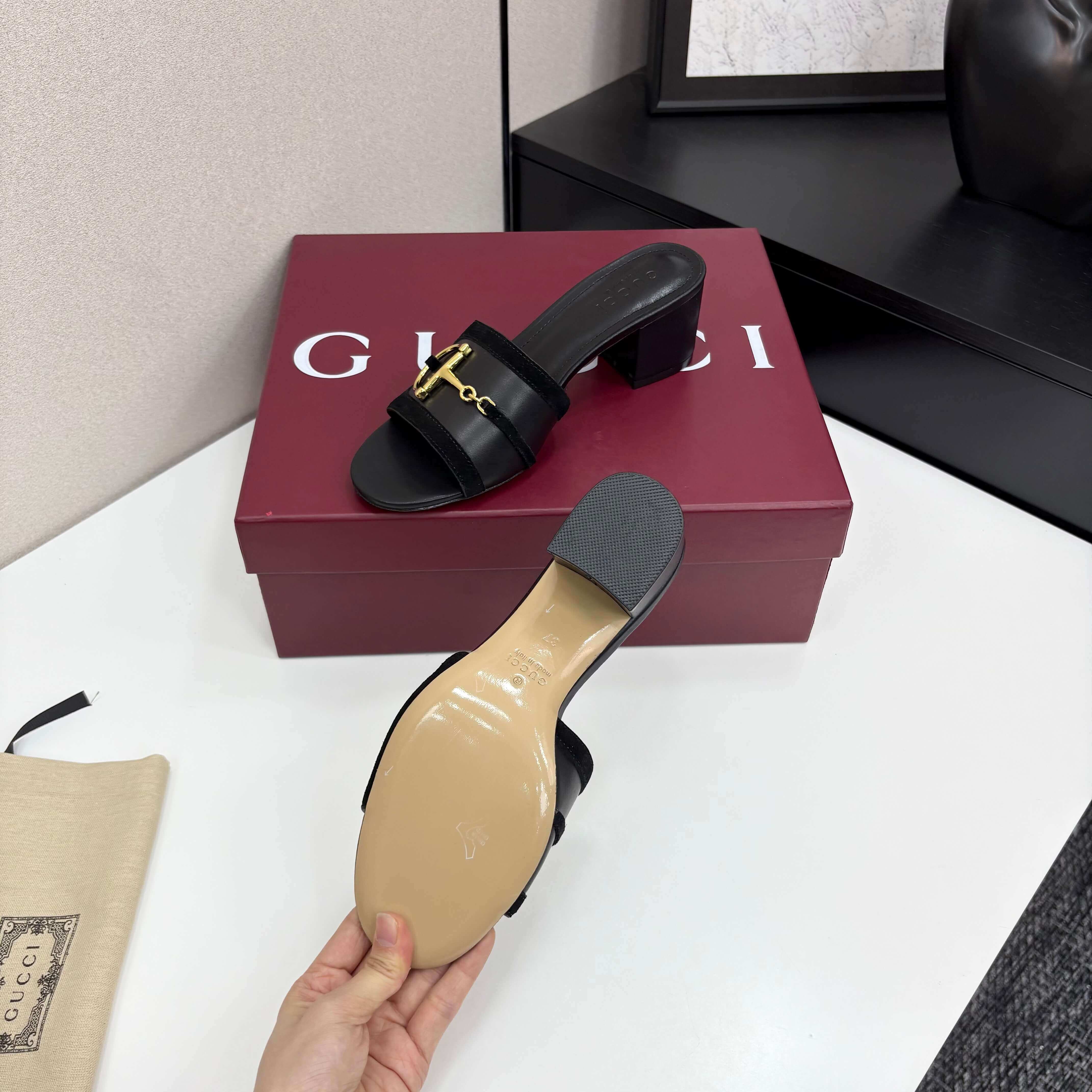 a pair of Gucci Women's Black Suede Block Heel Slide Sandals with Horsebit and GG Monogram Canvas