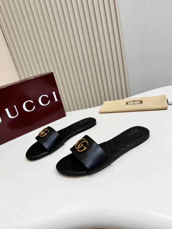 a pair of Gucci Women's Double G slide sandal - Black with gold letters on them