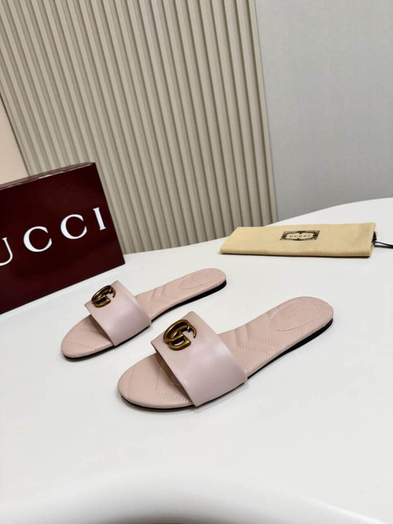a pair of Gucci Women's Double G slide sandal - Pink on a white table