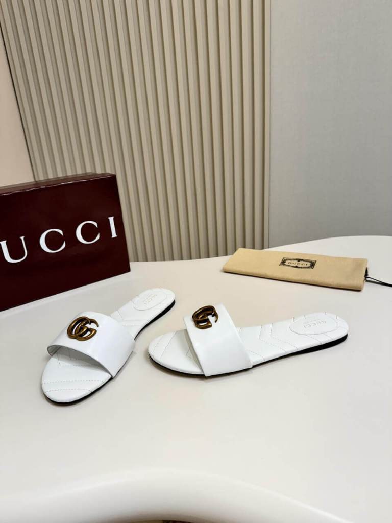 a pair of Gucci Women's Double G slide sandal - White on a table