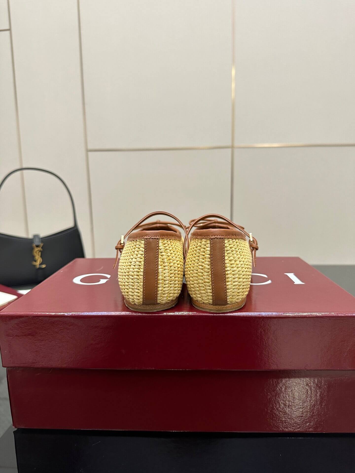 a pair of Gucci Women's Horsebit Ballet Flat - Natural Raffia on a box