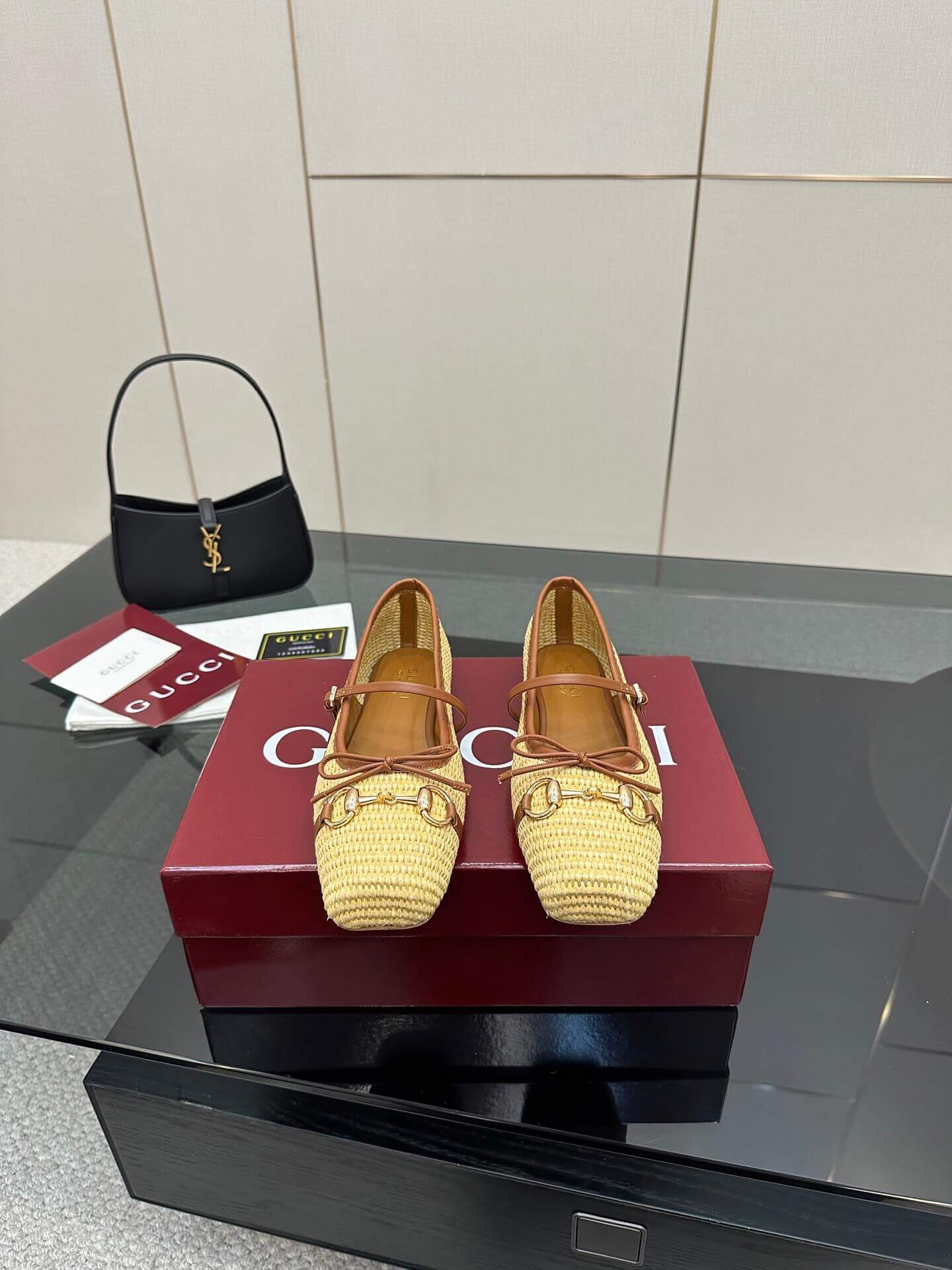 a pair of Gucci Women's Horsebit Ballet Flat - Natural Raffia on a box