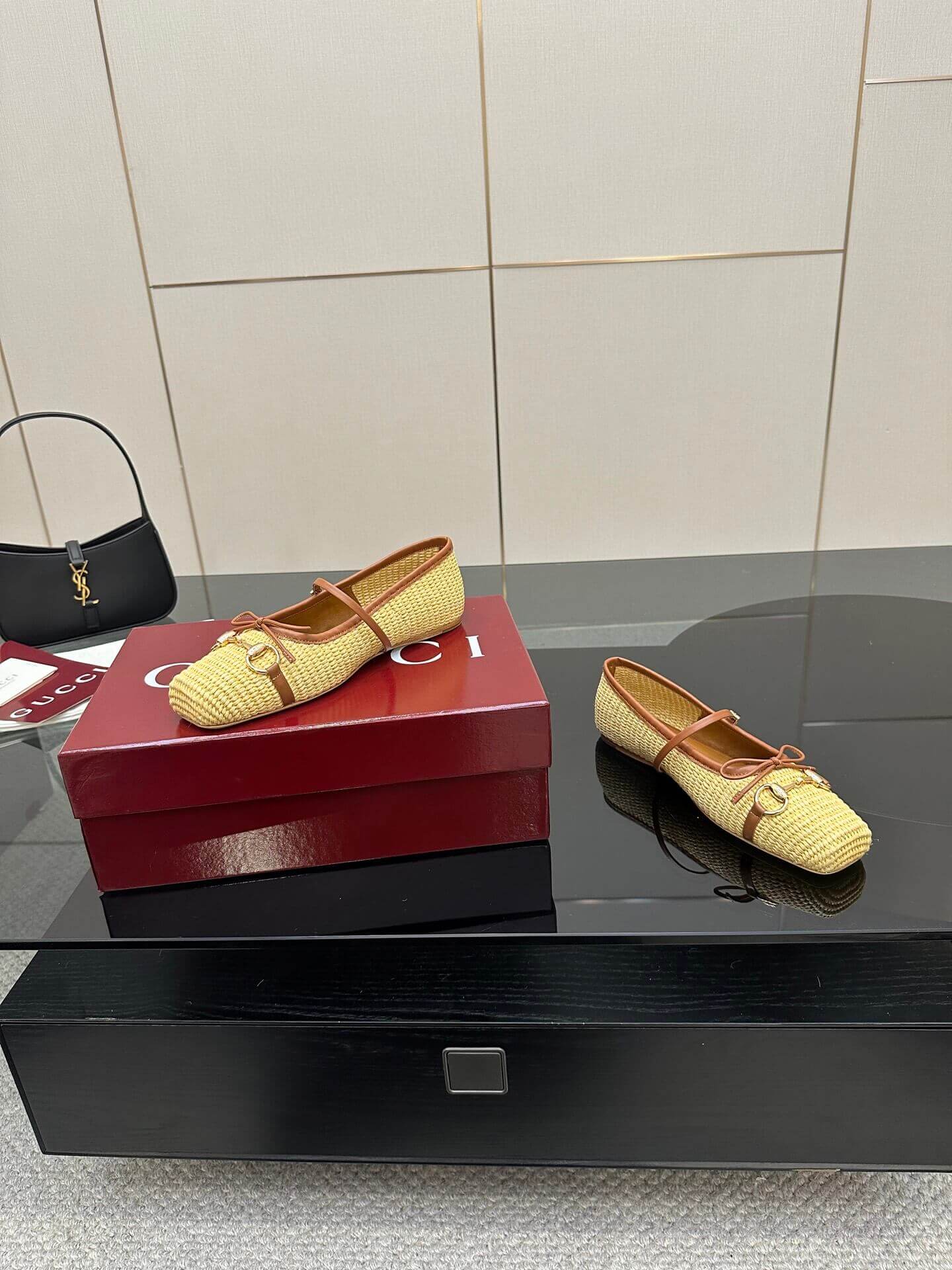 a pair of Gucci Women's Horsebit Ballet Flat - Natural Raffia on a box