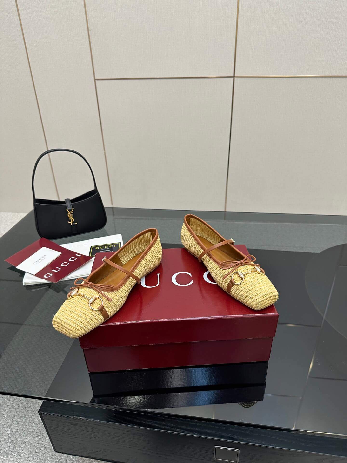 a pair of Gucci Women's Horsebit Ballet Flat - Natural Raffia on a box