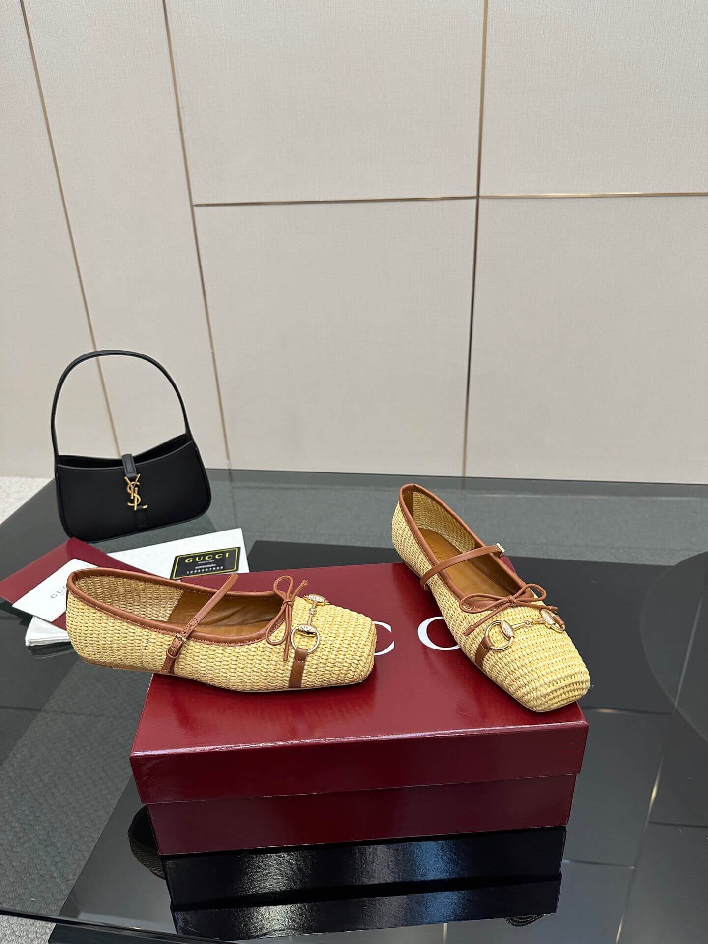 a pair of Gucci Women's Horsebit Ballet Flat - Natural Raffia on a box