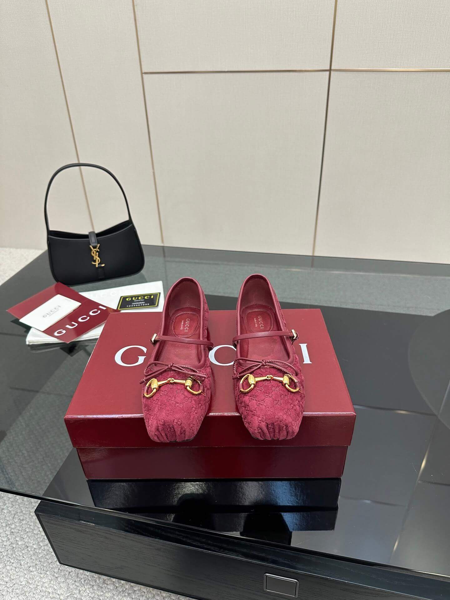 a pair of Gucci Women's Horsebit Ballet Flat - Rosso Ancora Red Original GG Canvas on a box