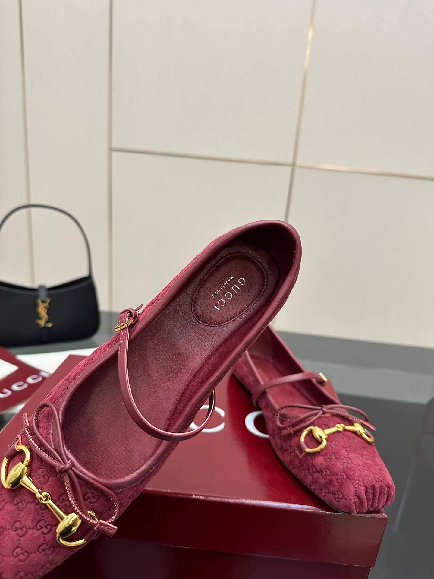 a pair of Gucci Women's Horsebit Ballet Flat - Rosso Ancora Red Original GG Canvas on a box