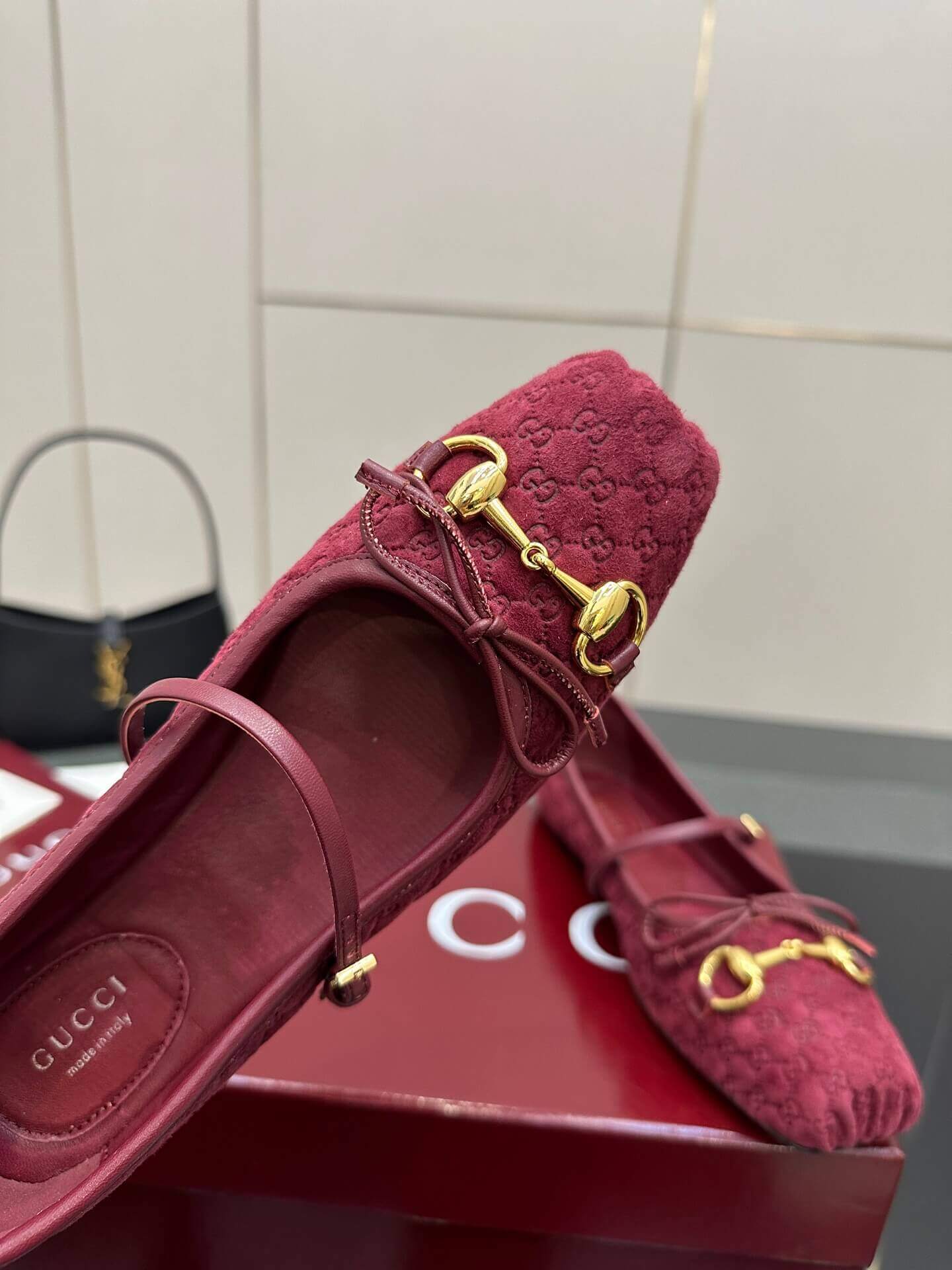 a pair of Gucci Women's Horsebit Ballet Flat - Rosso Ancora Red Original GG Canvas on a box