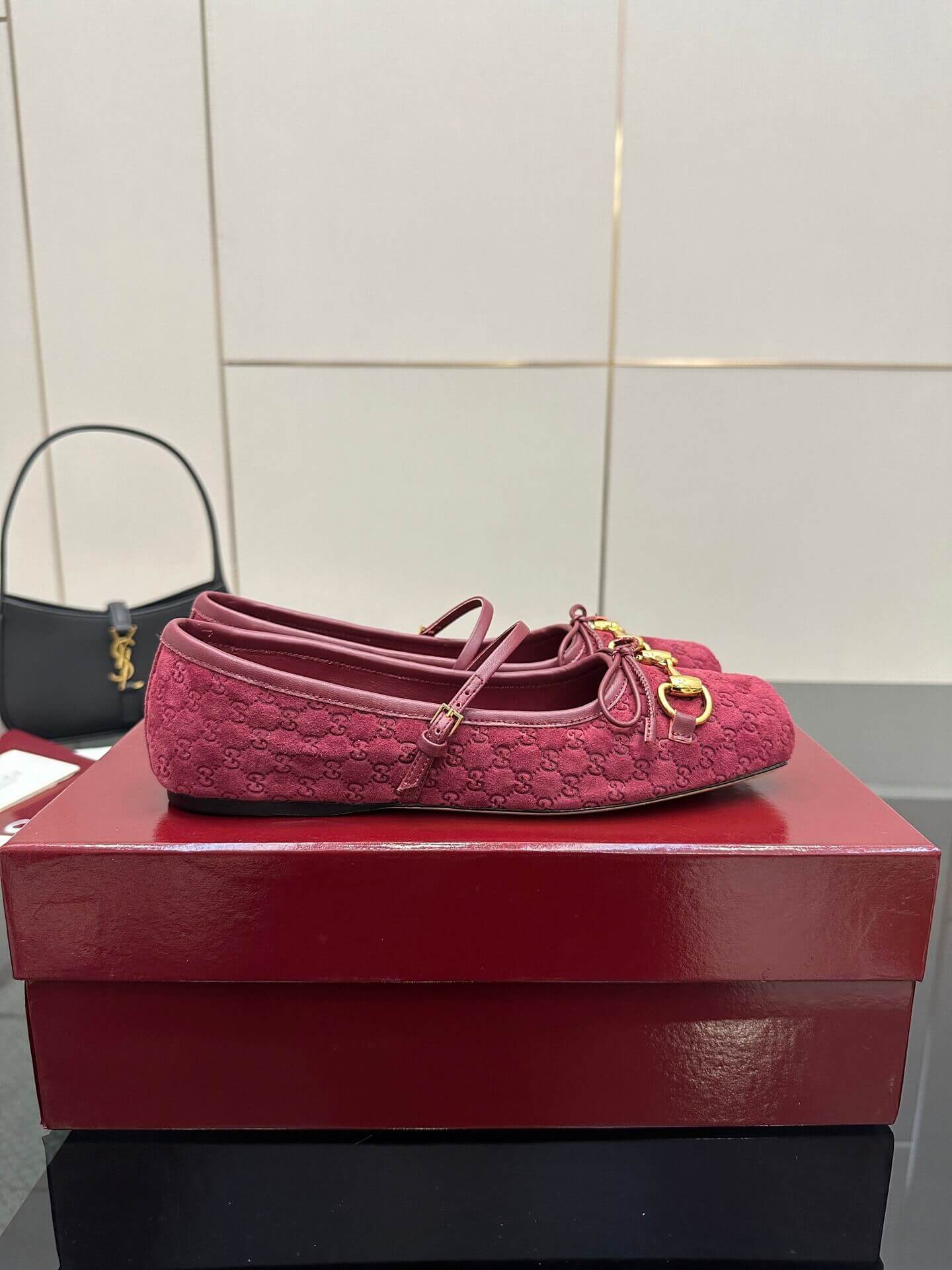 a pair of Gucci Women's Horsebit Ballet Flat - Rosso Ancora Red Original GG Canvas on a box
