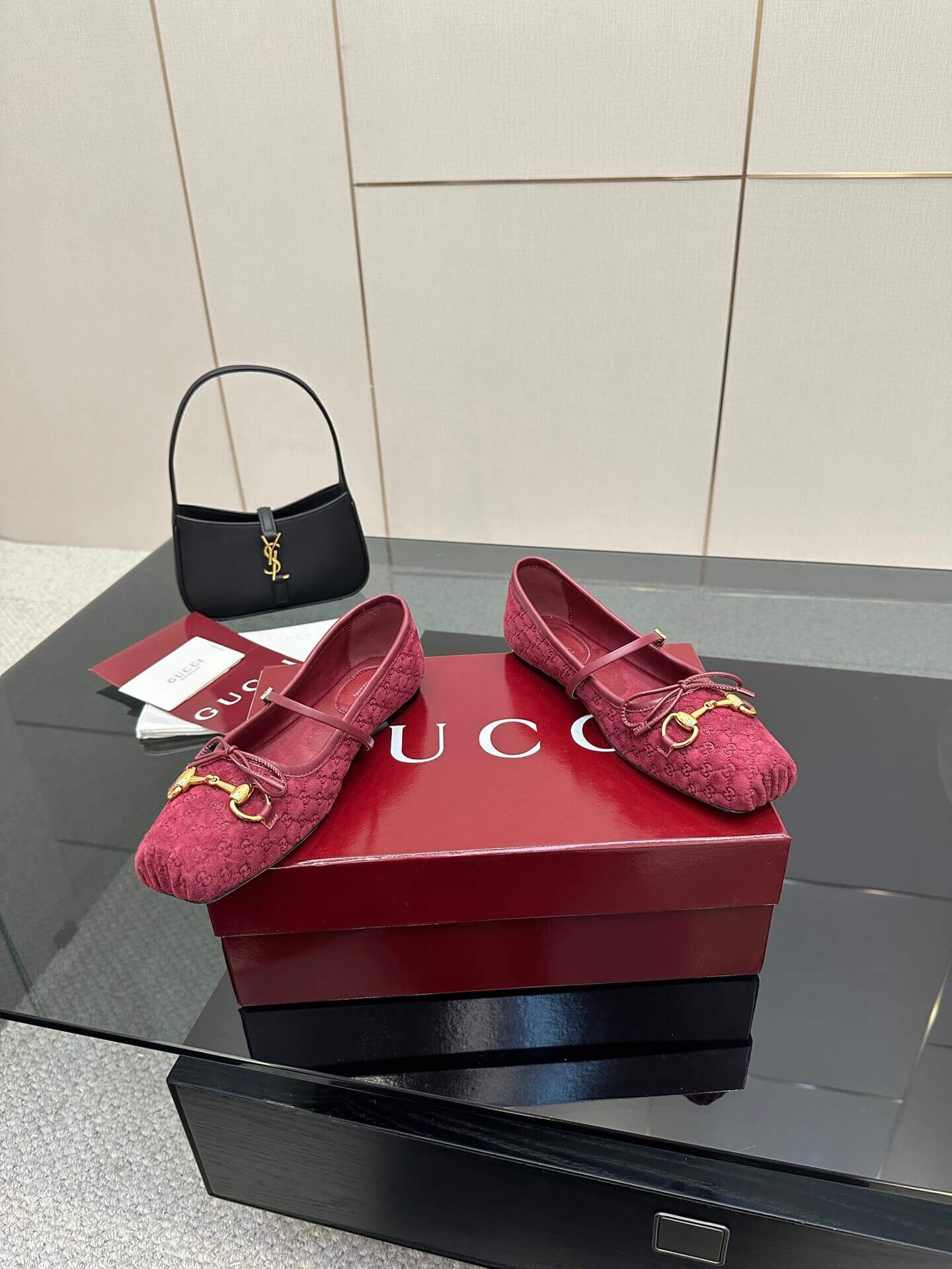 a pair of Gucci Women's Horsebit Ballet Flat - Rosso Ancora Red Original GG Canvas on a box