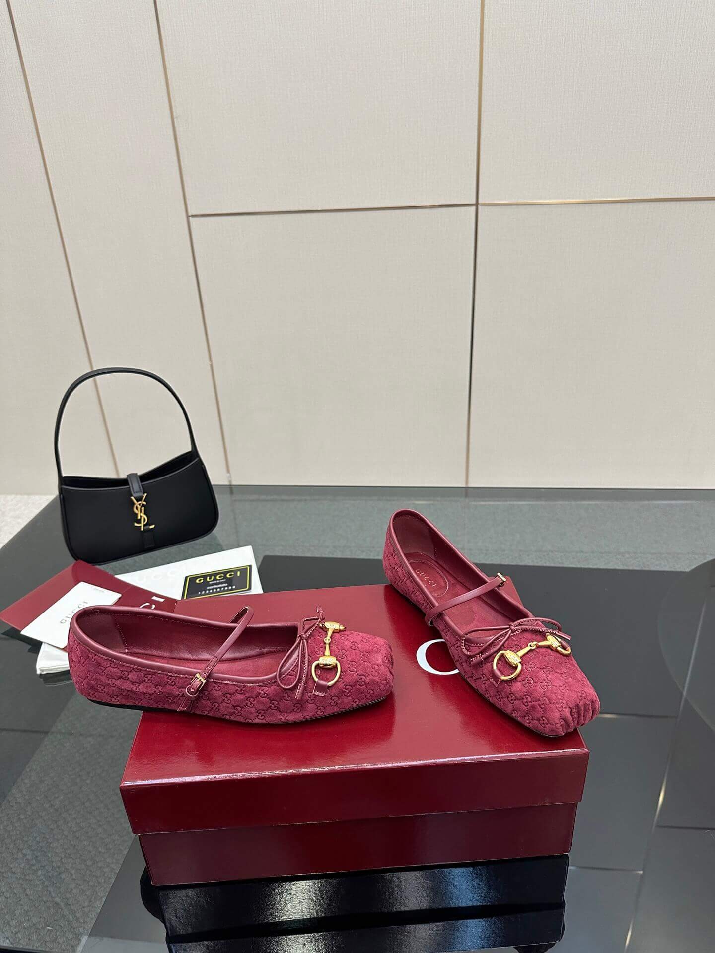 a pair of Gucci Women's Horsebit Ballet Flat - Rosso Ancora Red Original GG Canvas on a box