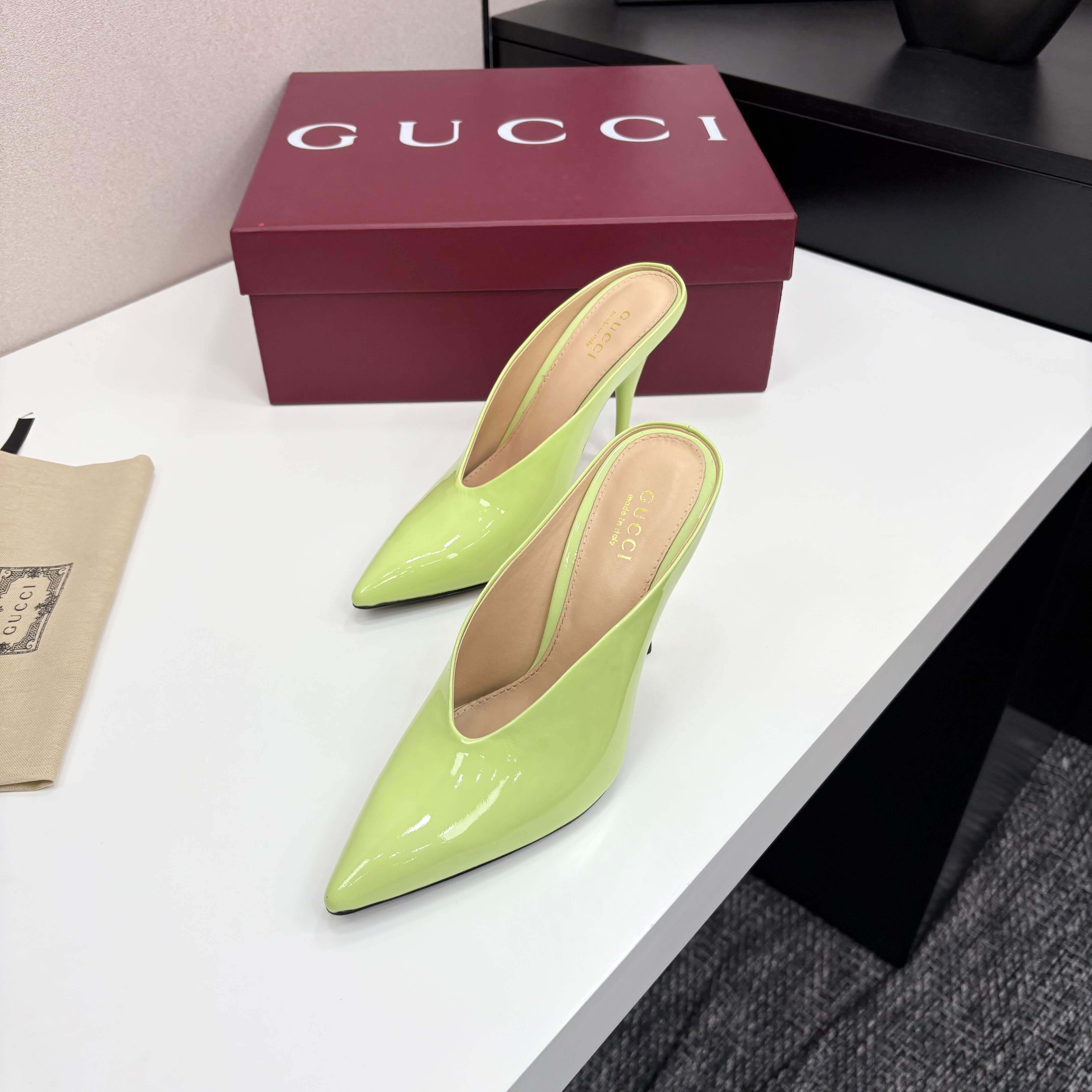 a pair of Gucci Women's Lime Green Shiny Patent Leather Pointed-Toe Stiletto Pumps on a red box