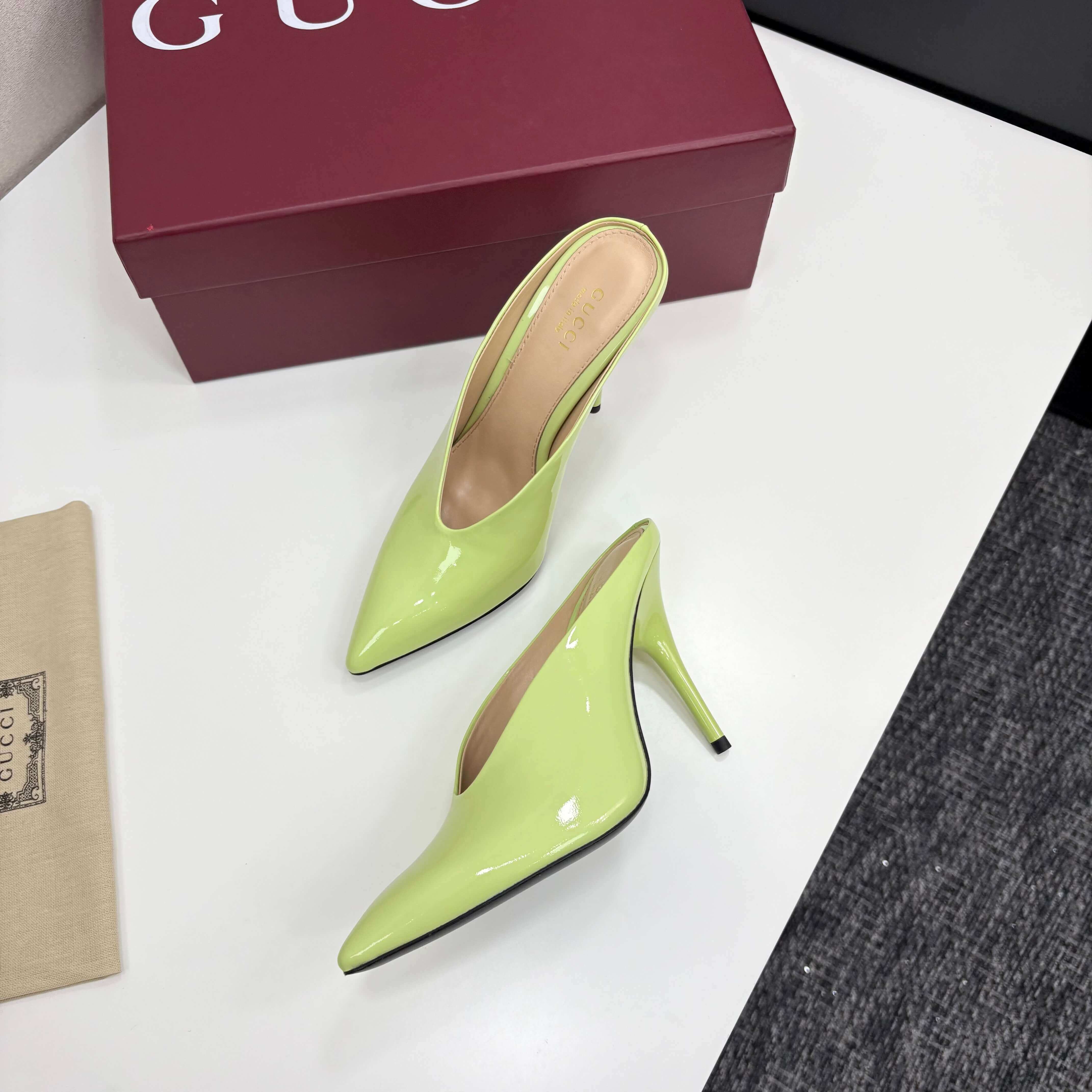 a pair of Gucci Women's Lime Green Shiny Patent Leather Pointed-Toe Stiletto Pumps on a red box