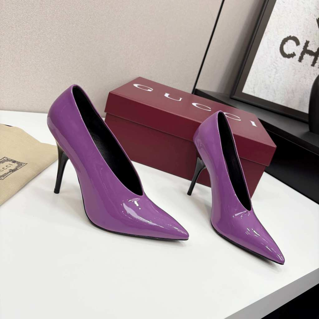 a pair of Gucci Women's Purple Shiny Patent Leather Pointed-Toe Stiletto Pumps on a white table