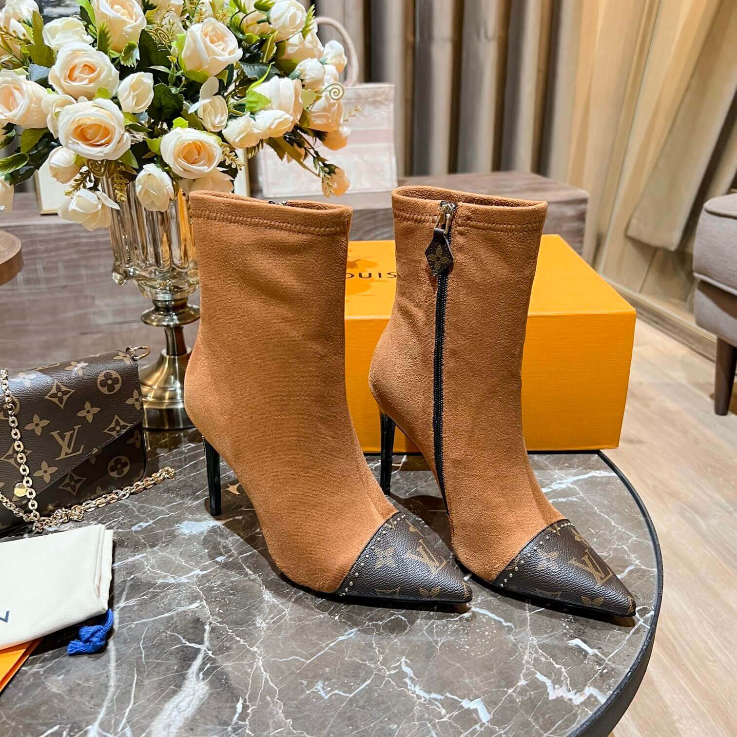 a pair of Louis Vuitton-Inspired Cherrie Ankle Boots In Tan Monogram on a table