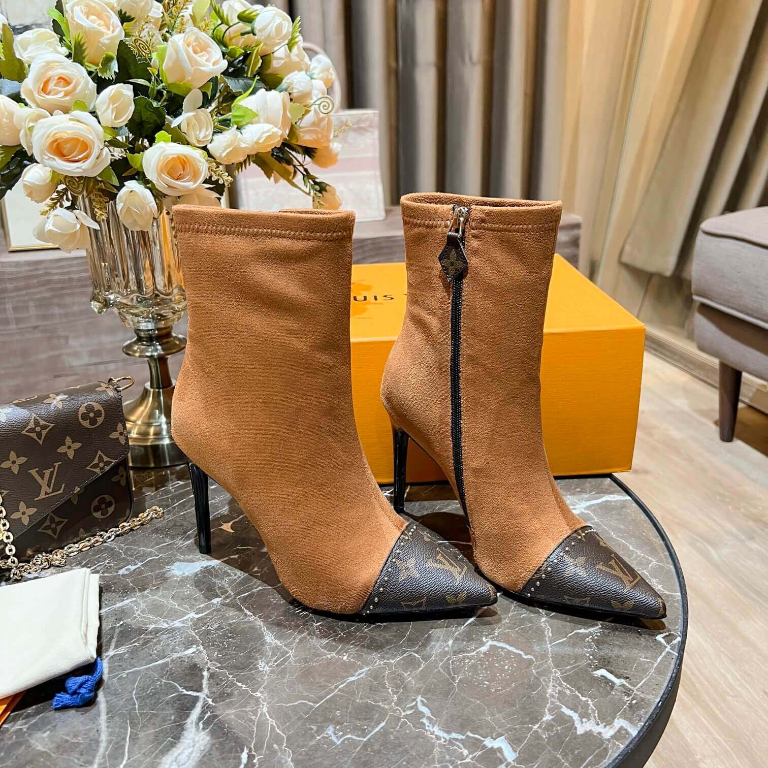 a pair of Louis Vuitton-Inspired Cherrie Ankle Boots In Tan Monogram on a table