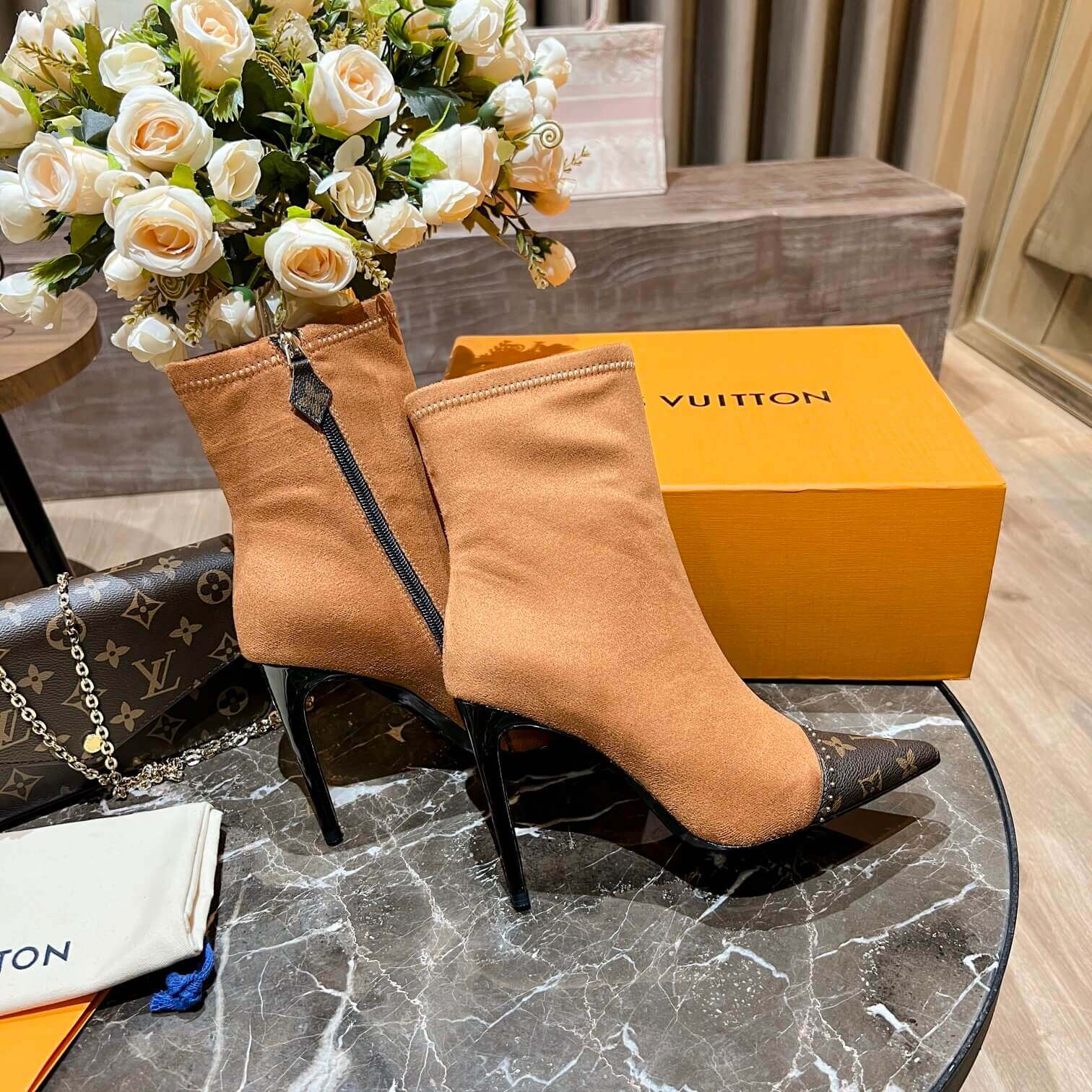 a pair of Louis Vuitton-Inspired Cherrie Ankle Boots In Tan Monogram on a table