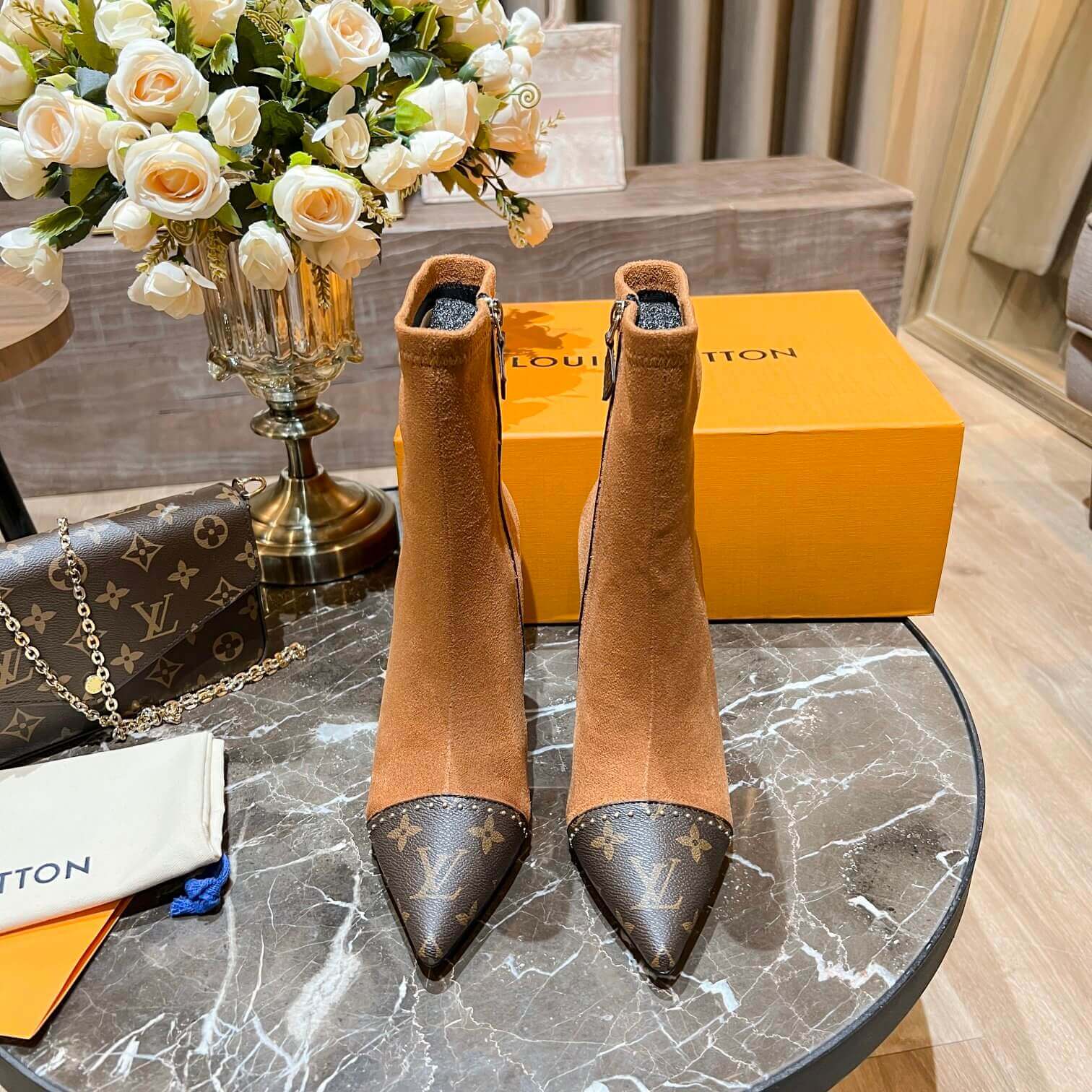 a pair of Louis Vuitton-Inspired Cherrie Ankle Boots In Tan Monogram on a table