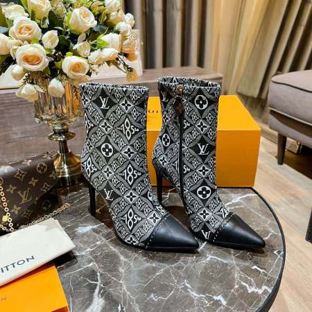 a pair of Louis Vuitton-Inspired Cherrie Ankle Boots – Monogram Noir on a table