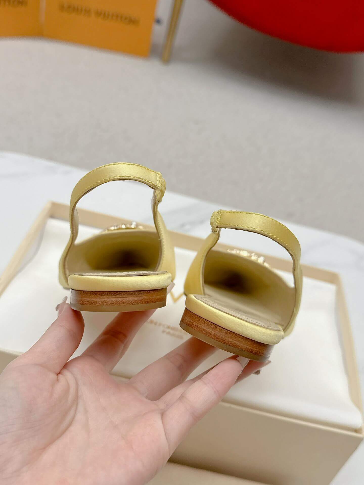a pair of Louis Vuitton-Inspired Satin Slingback Flats – Yellow on a box