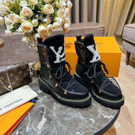 a pair of Louis Vuitton Beaubourg Ankle Boots (Black) on a table