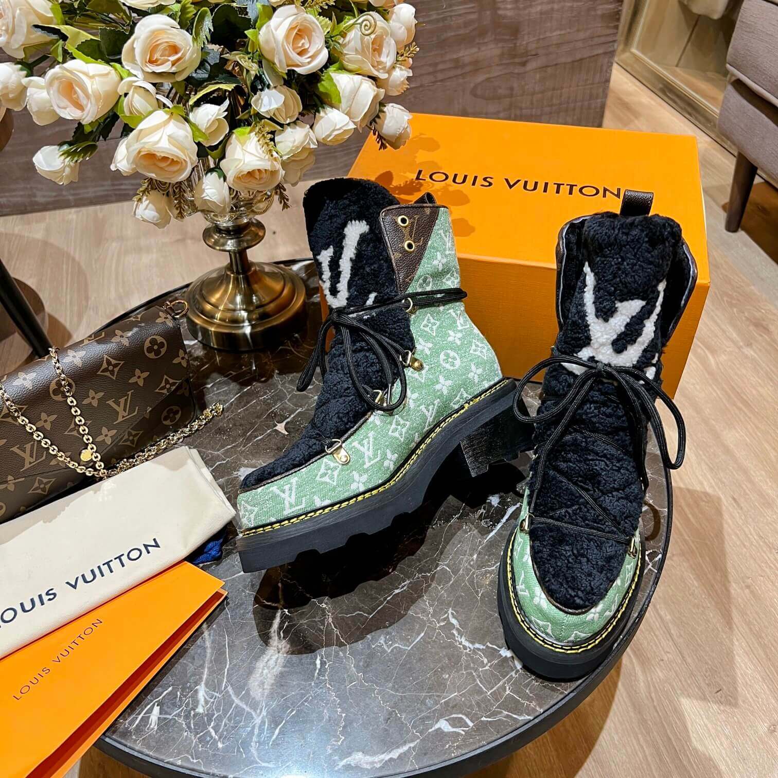 a pair of Louis Vuitton Beaubourg Ankle Boots (Green Monogram) on a table
