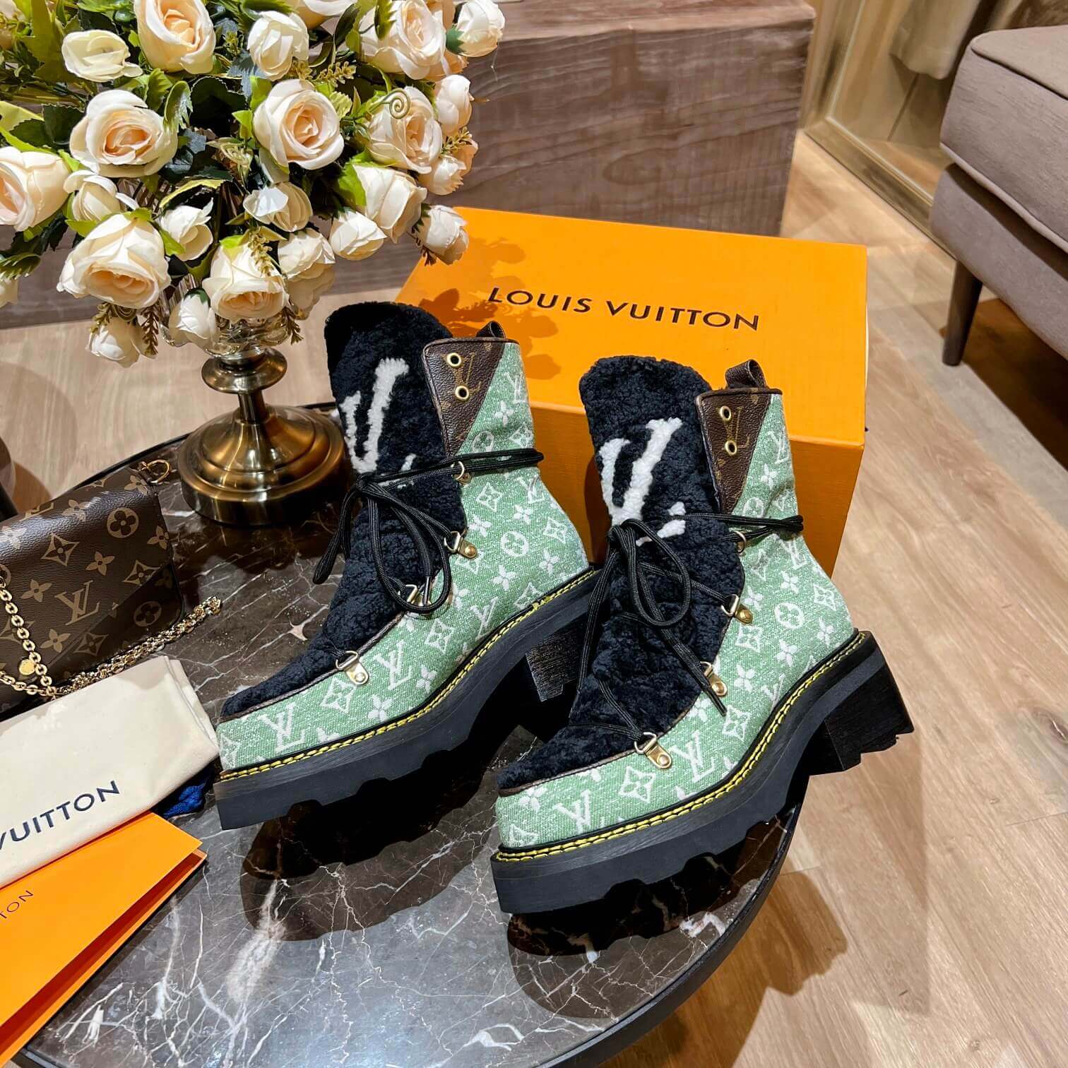 a pair of Louis Vuitton Beaubourg Ankle Boots (Green Monogram) on a table
