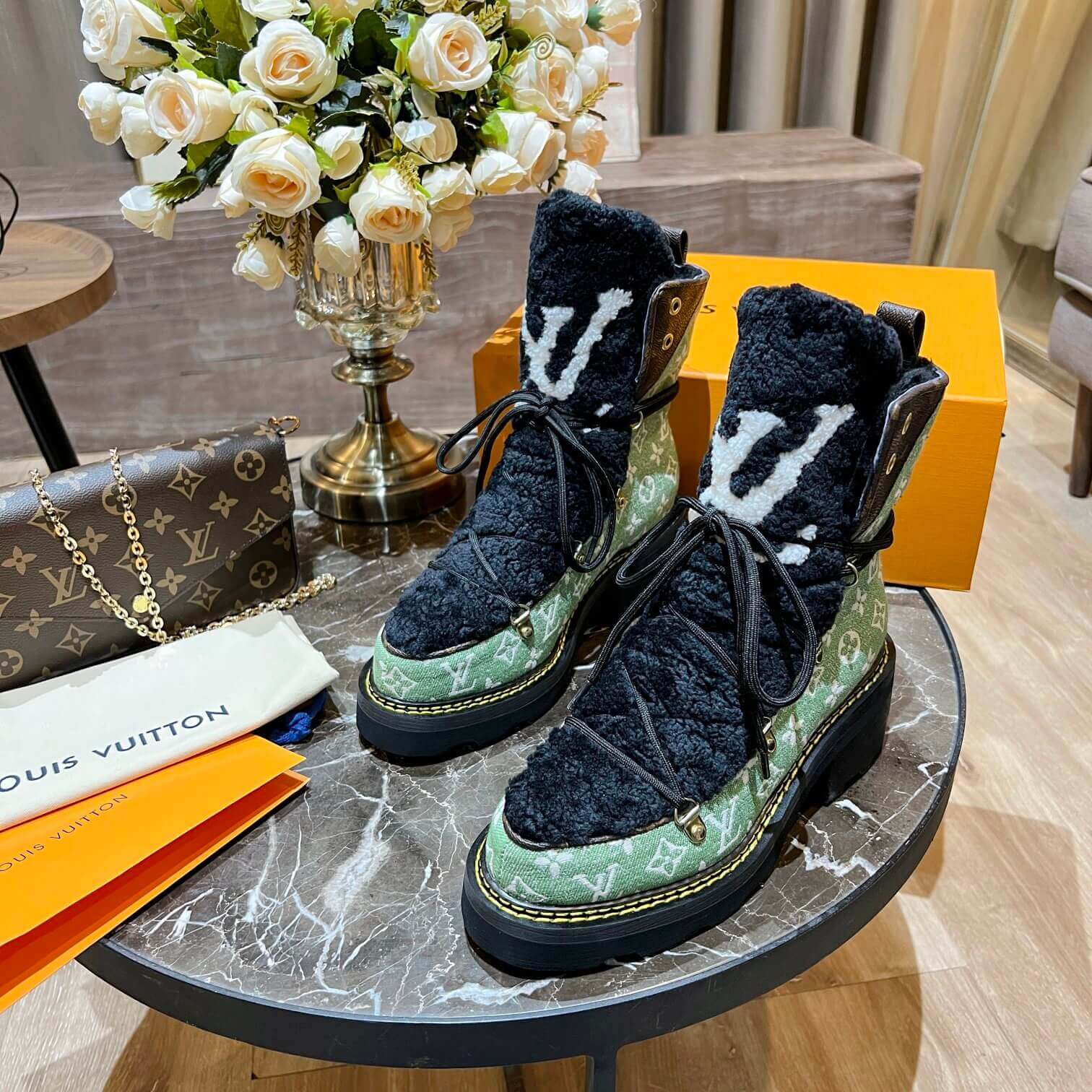 a pair of Louis Vuitton Beaubourg Ankle Boots (Green Monogram) on a table
