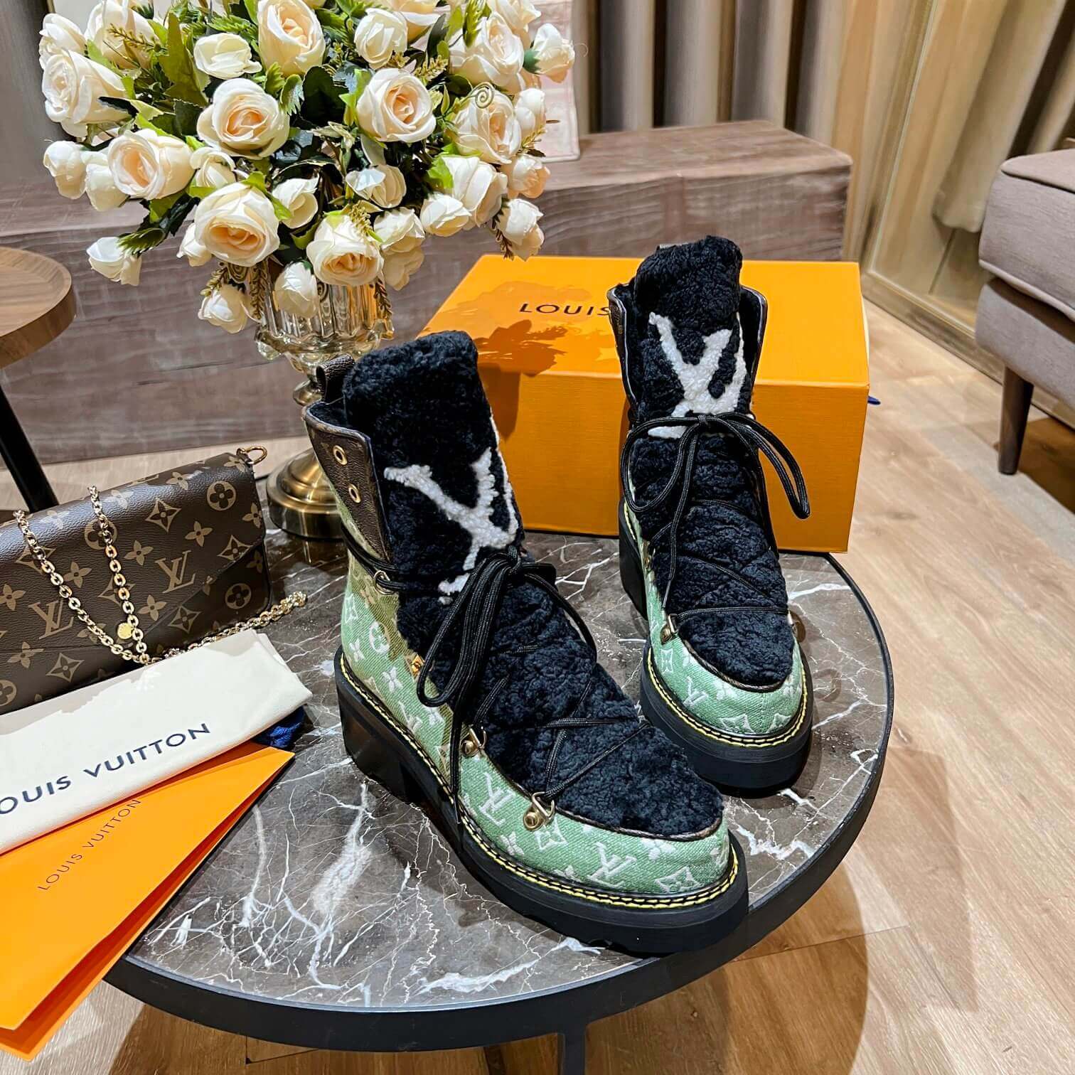 a pair of Louis Vuitton Beaubourg Ankle Boots (Green Monogram) on a table
