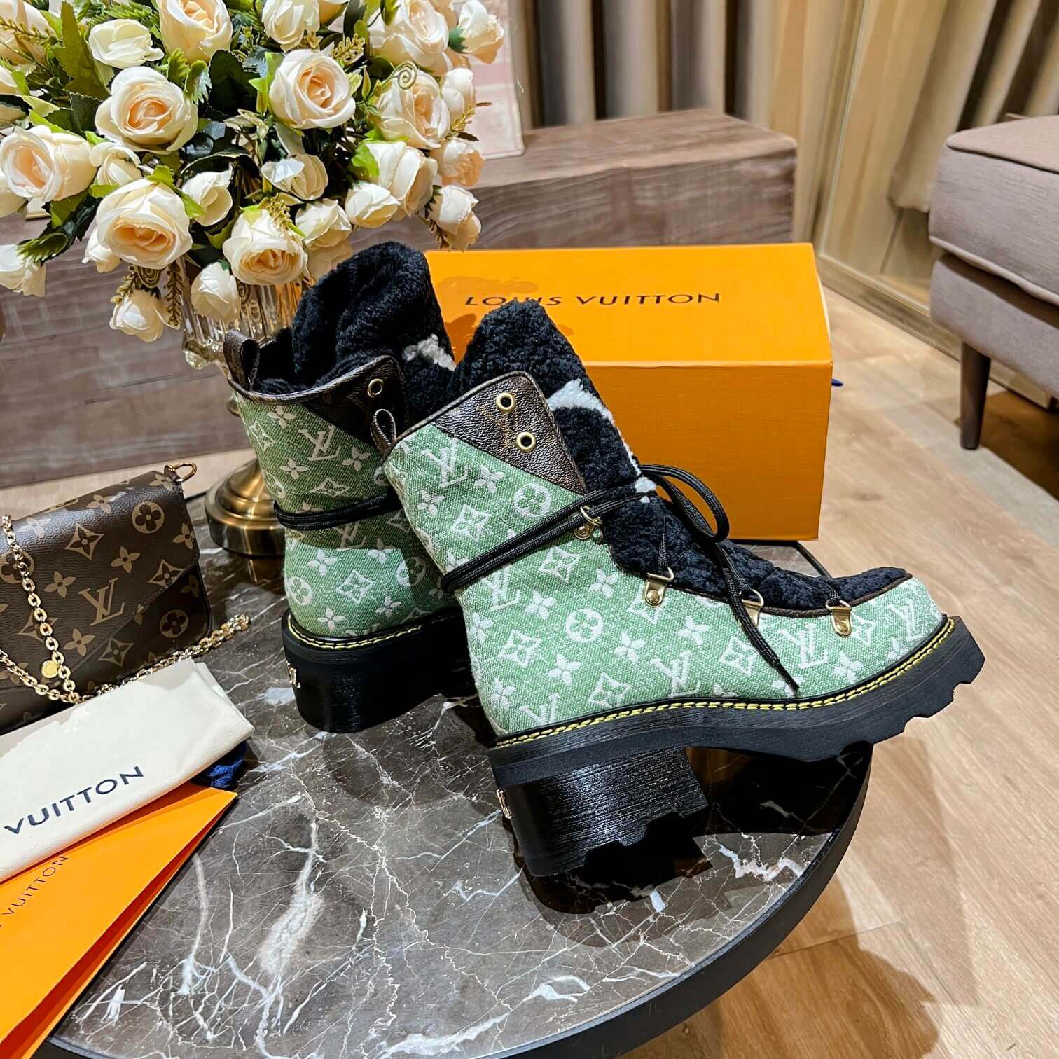 a pair of Louis Vuitton Beaubourg Ankle Boots (Green Monogram) on a table