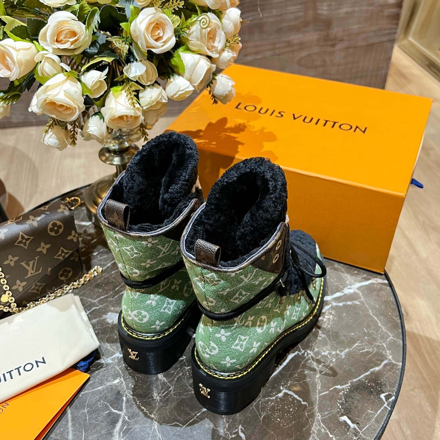 a pair of Louis Vuitton Beaubourg Ankle Boots (Green Monogram) on a table