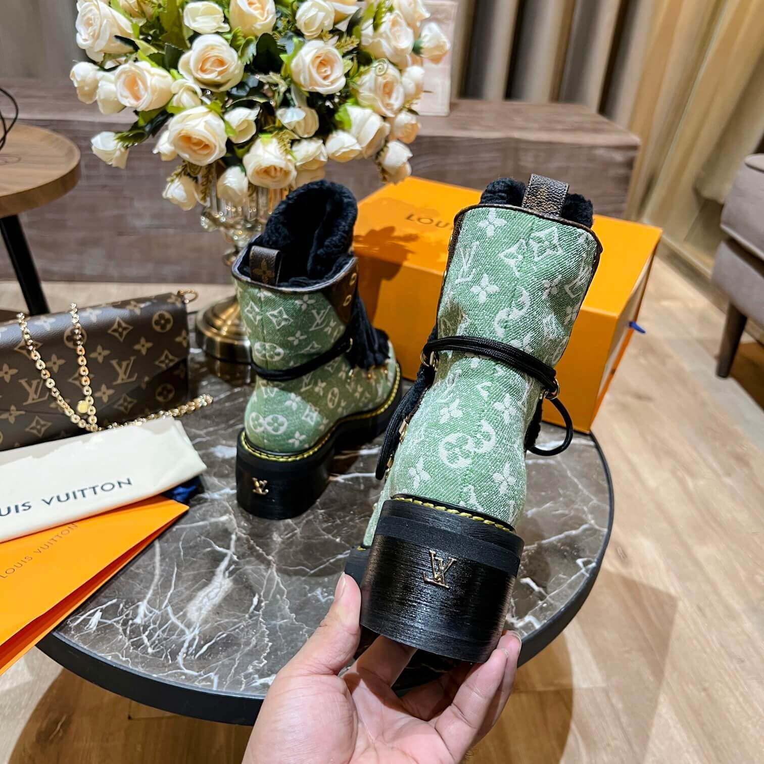 a pair of Louis Vuitton Beaubourg Ankle Boots (Green Monogram) on a table