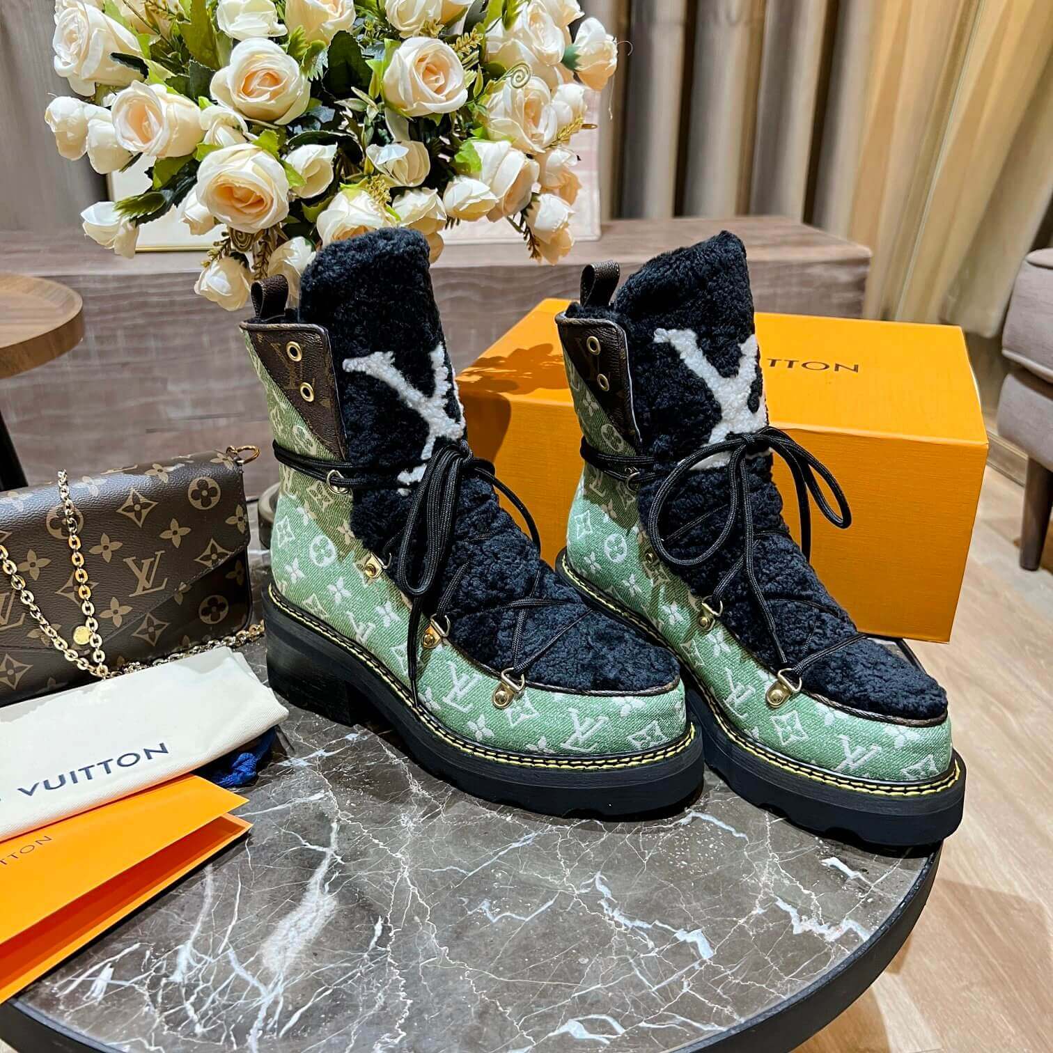 a pair of Louis Vuitton Beaubourg Ankle Boots (Green Monogram) on a table
