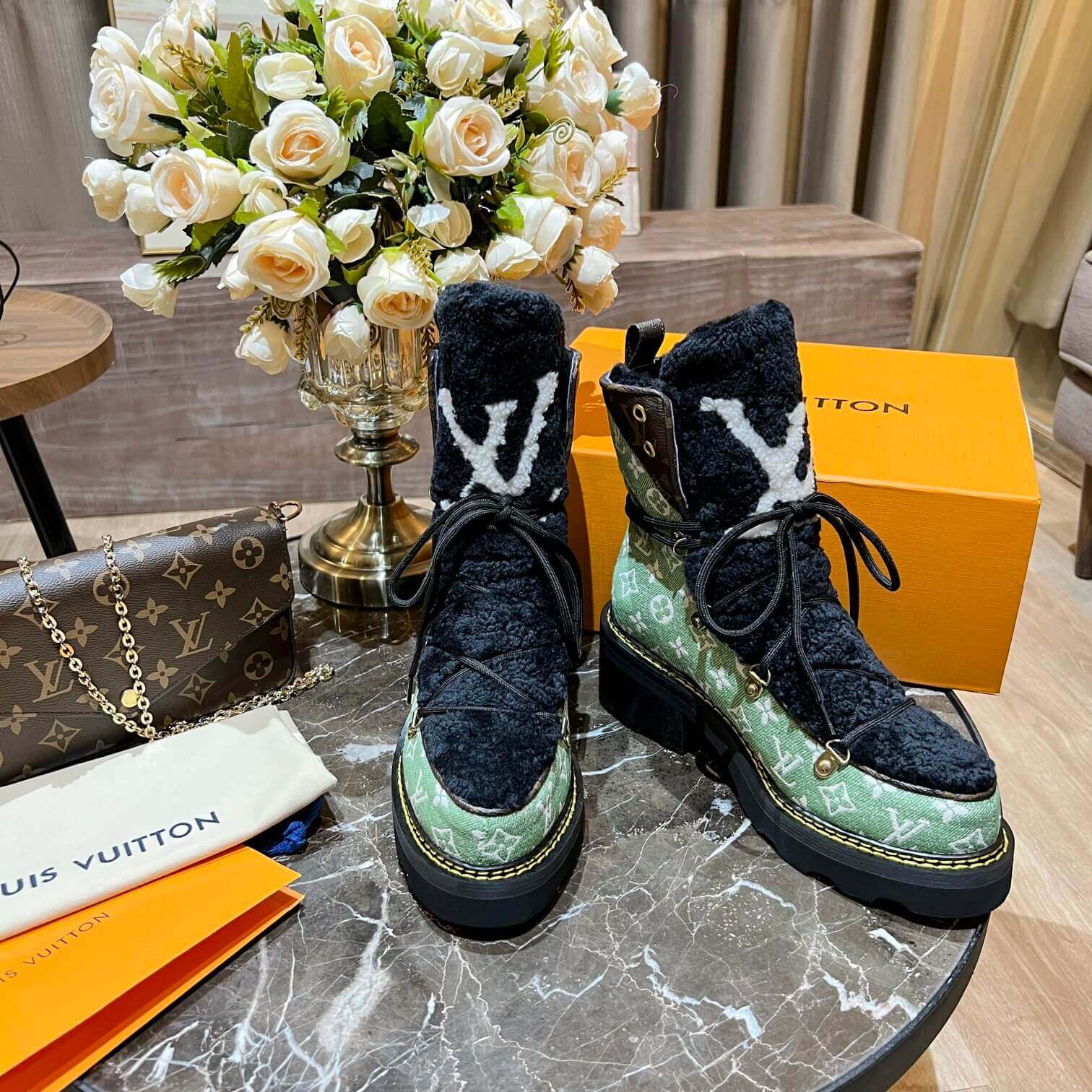 a pair of Louis Vuitton Beaubourg Ankle Boots (Green Monogram) on a table