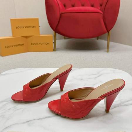 a pair of Louis Vuitton Call Back Super Mules – Vibrant Red Patent on a marble table