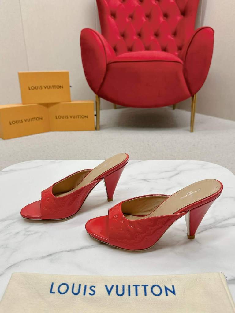 a pair of Louis Vuitton Call Back Super Mules – Vibrant Red Patent on a marble table