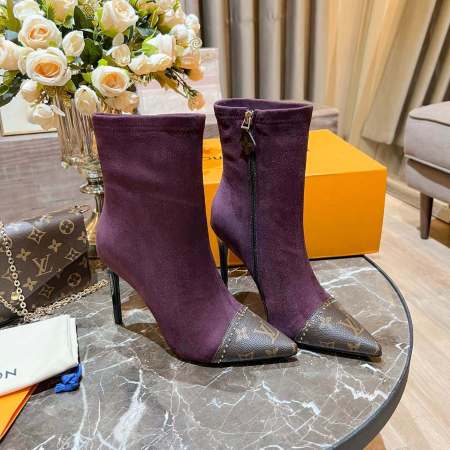 a pair of Louis Vuitton Cherie Ankle Boots iN Purple on a table