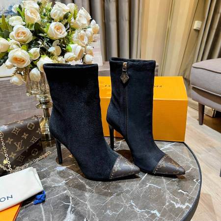 a pair of Louis Vuitton Cherie Ankle Boots in Black Leather on a marble table