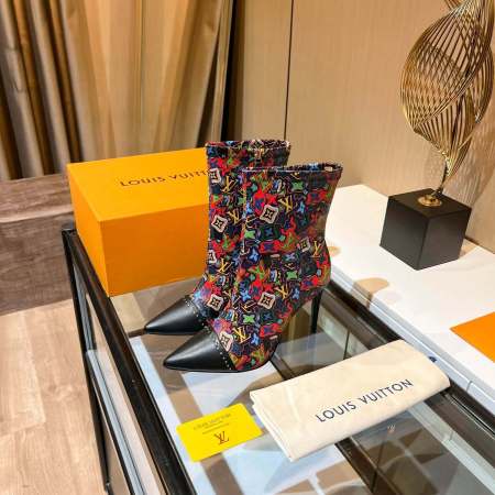 a pair of Louis Vuitton Cherrie Ankle Boots – Elegant Glossy Finish on a marble table