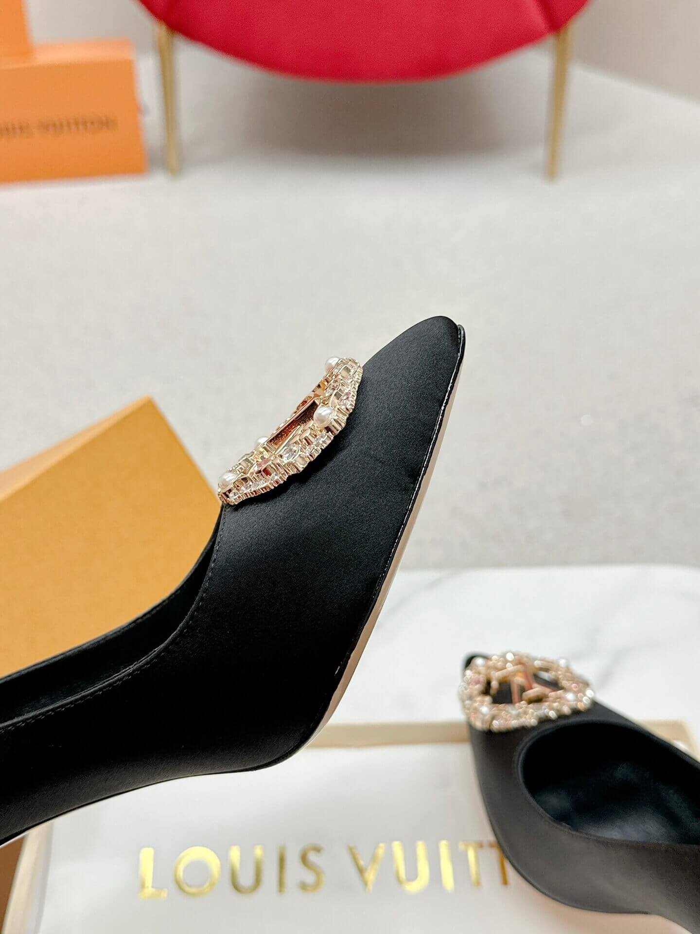 a pair of Louis Vuitton Elegant Black Satin Crystal Heels on a marble table