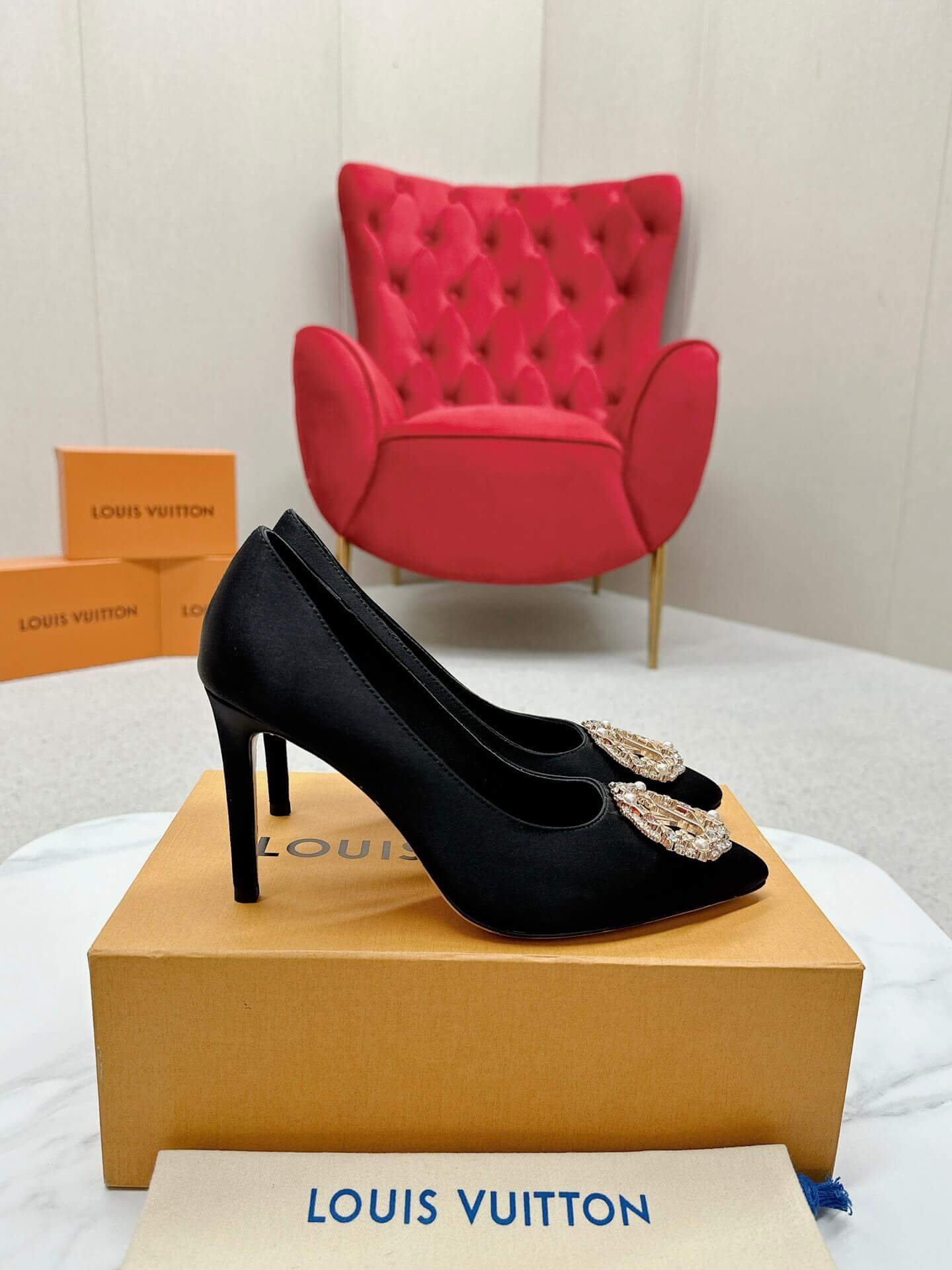 a pair of Louis Vuitton Elegant Black Satin Crystal Heels on a marble table