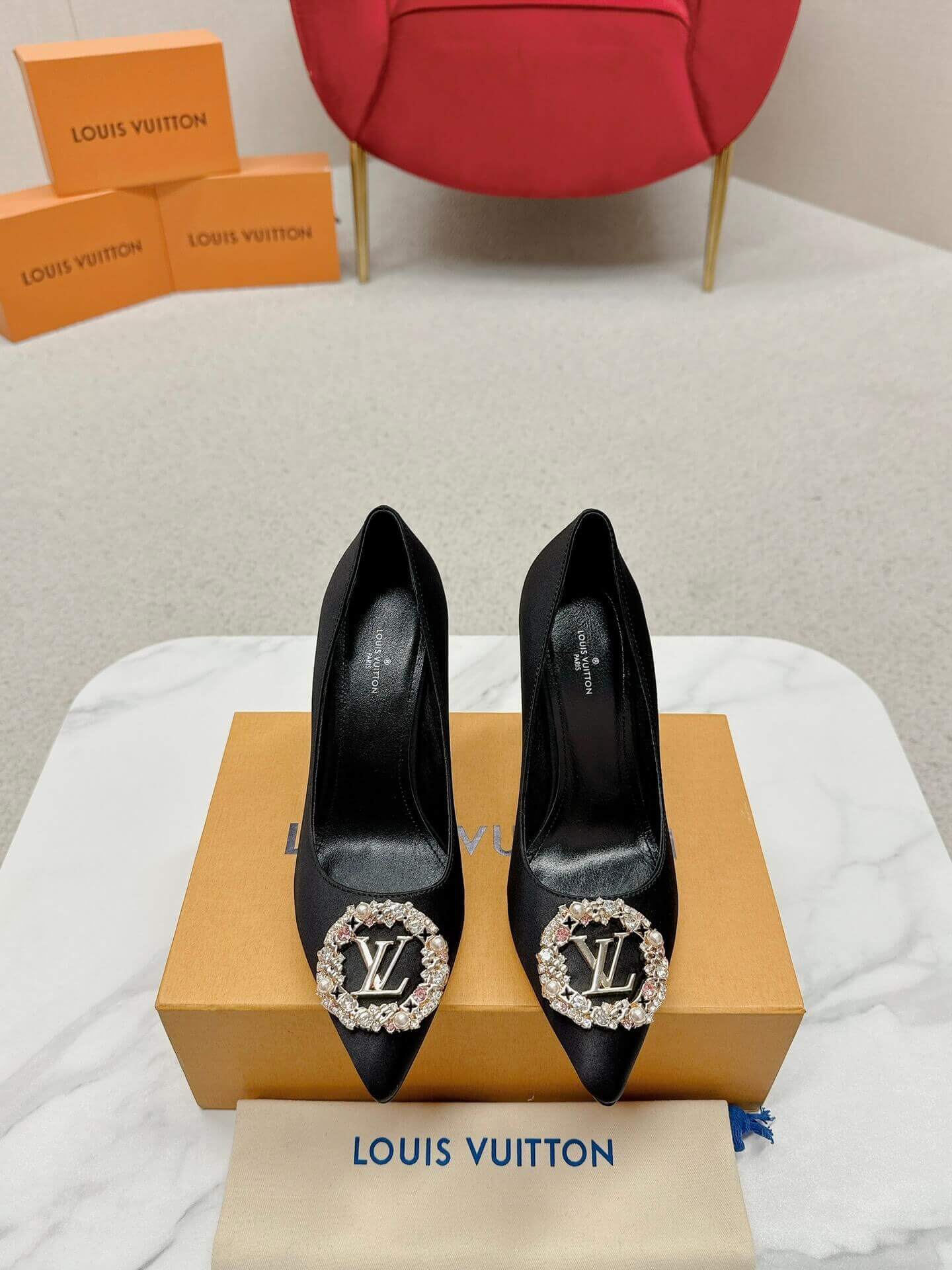 a pair of Louis Vuitton Elegant Black Satin Crystal Heels on a marble table