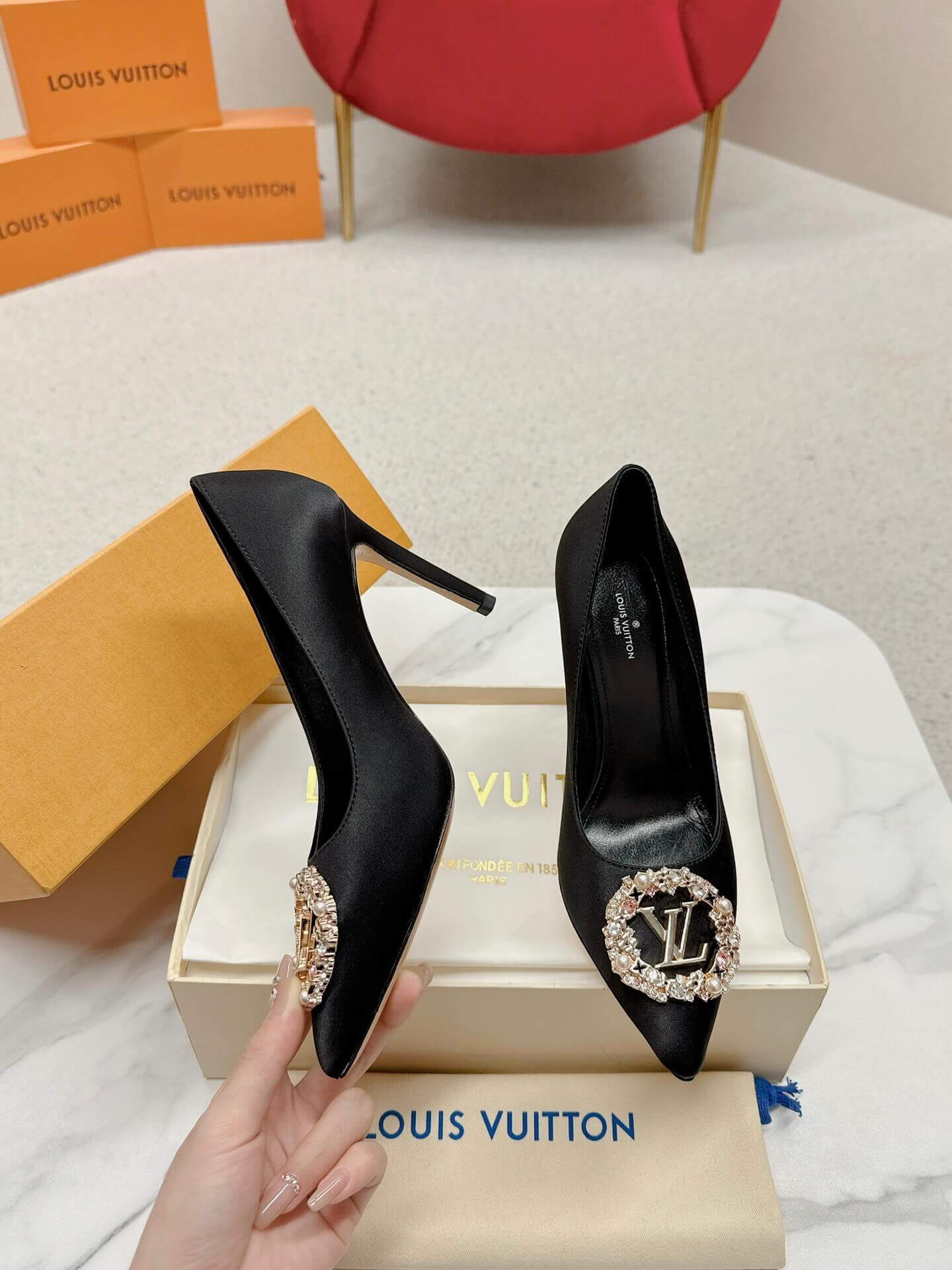 a pair of Louis Vuitton Elegant Black Satin Crystal Heels on a marble table