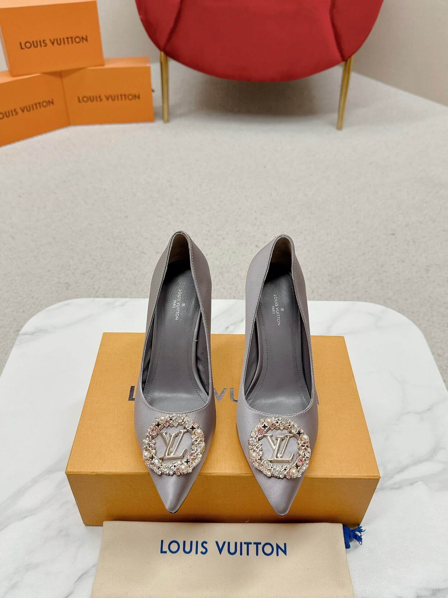 a pair of Louis Vuitton Elegant Crystal Pointed-Toe Pump – Grey on a marble table