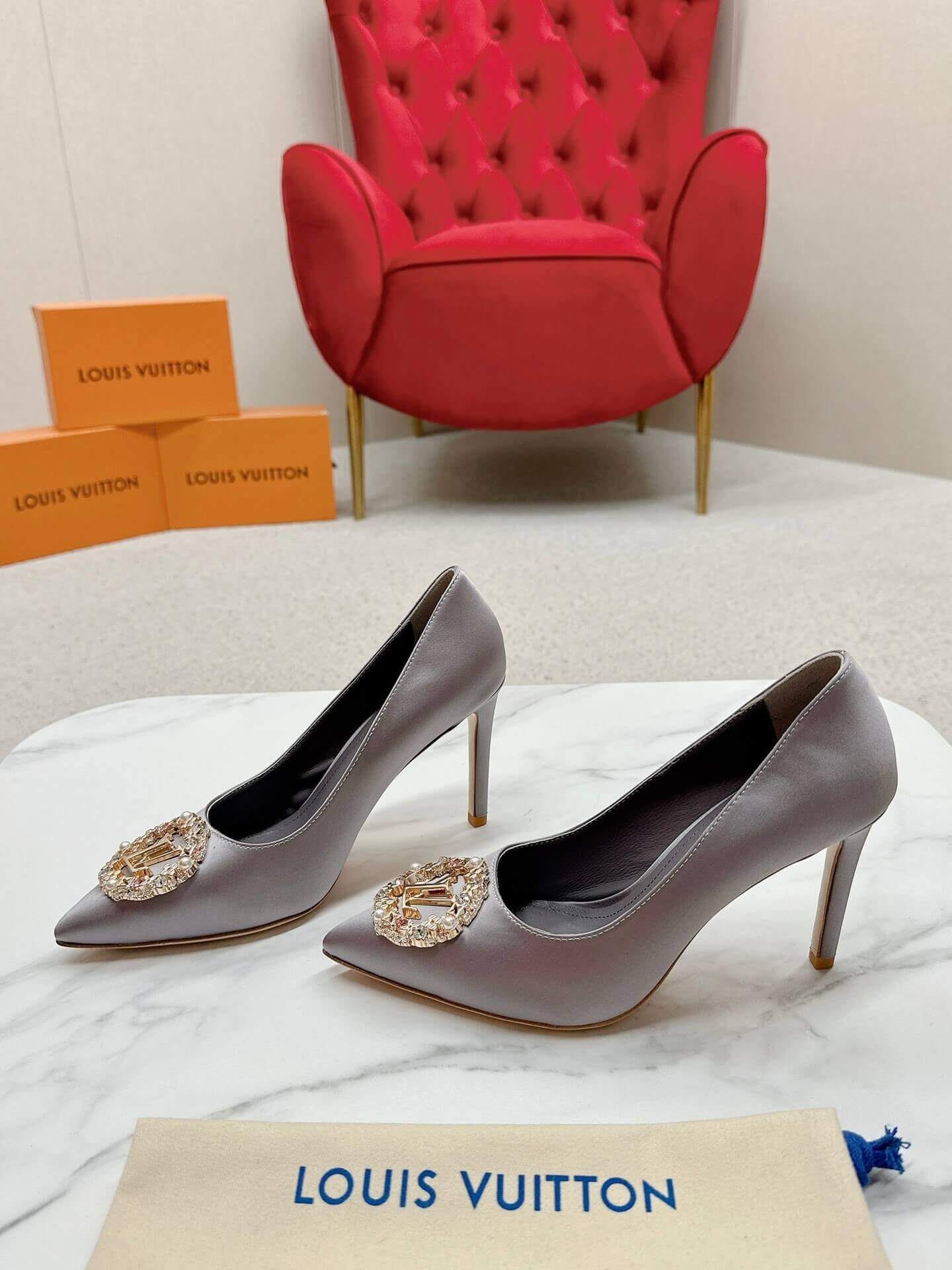 a pair of Louis Vuitton Elegant Crystal Pointed-Toe Pump – Grey on a marble table