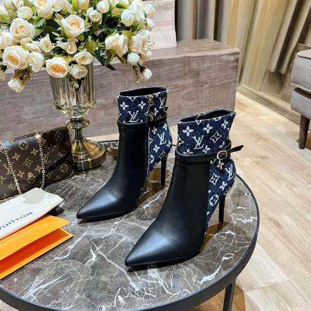 a pair of Louis Vuitton High-Heeled Ankle Boots In Black & Blue Monogram on a marble table