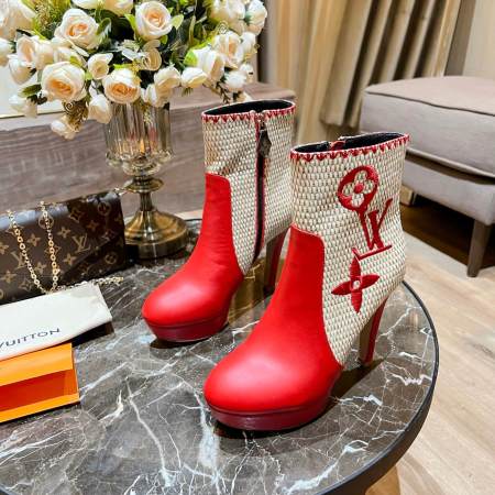 a pair of Louis Vuitton High-Heeled Ankle Boots In Red & Embroidered Monogramon a marble table