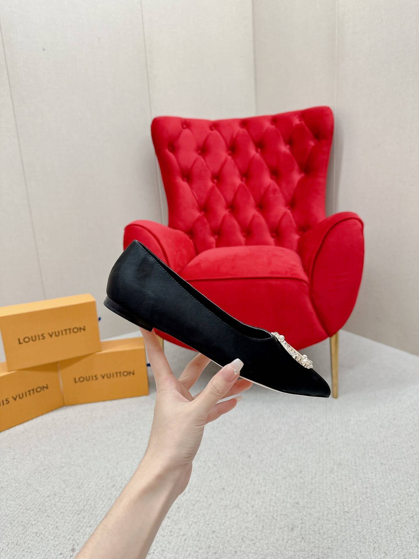a pair of Louis Vuitton Inspired Crystal Embellished Satin Flats in Black on a marble table chair